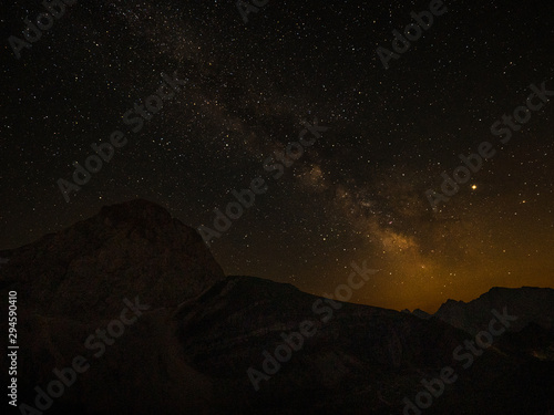 Countless stars fill up the night sky above the silhouettes of the Julian Alps.
