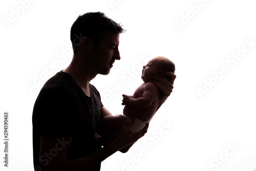 Silhouette of a father holding his newborn baby photo