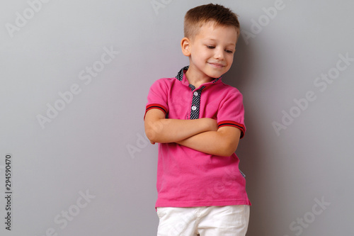 Canvas-taulu Cute little boy in pink T-shirt posing against grey background