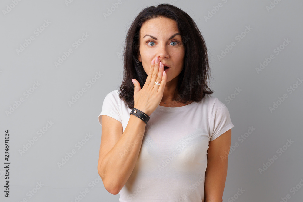 Young beautiful woman portrait being excited and amazed over gray background. Young beautiful woman portrait being excited and amazed over gray background.