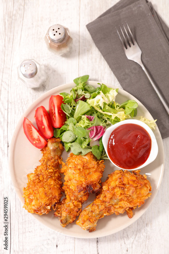 crispy chicken leg with salad and ketchup