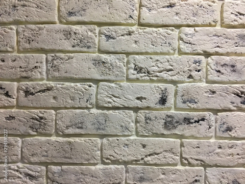white brick wall covered with lacquer with embroidery