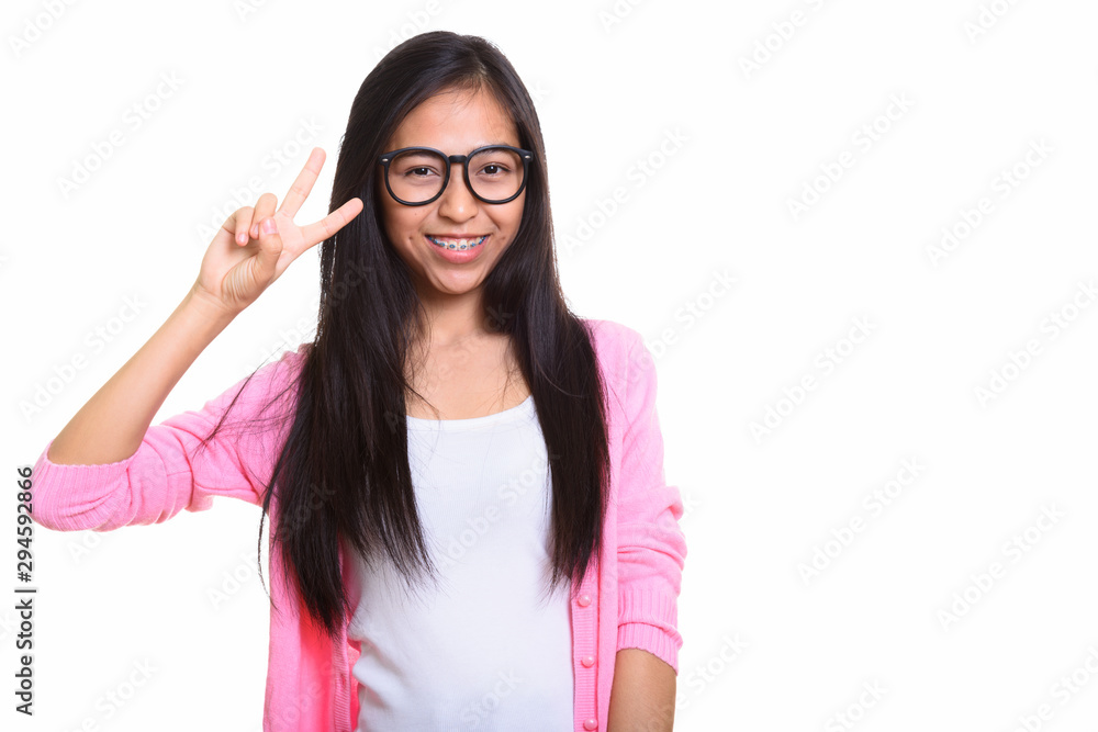 Studio shot of young happy Asian teenage girl smiling and giving Studio shot of young happy Asian teenage girl smiling and giving