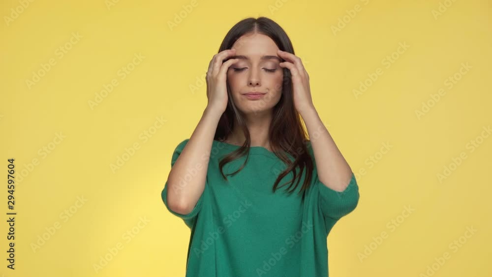 tired woman touching temples isolated on yellow tired woman touching temples isolated on yellow