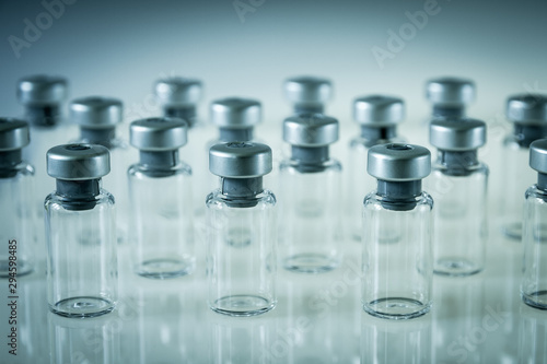 Vaccine glass bottles on grey background