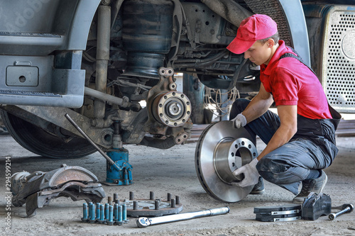 A mechanic repairs a truck. Replace brake disc and pads 