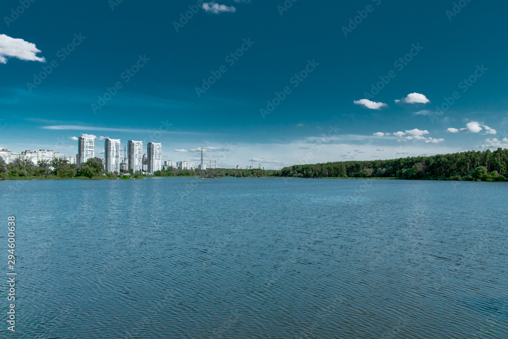 Wide lake with city and forest on the far shore