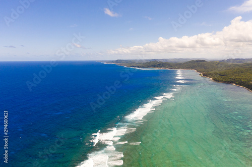 Seascape, coast of the island of Siargao, Philippines. Blue sea with waves and sky with big clouds, top view. © Tatiana Nurieva
