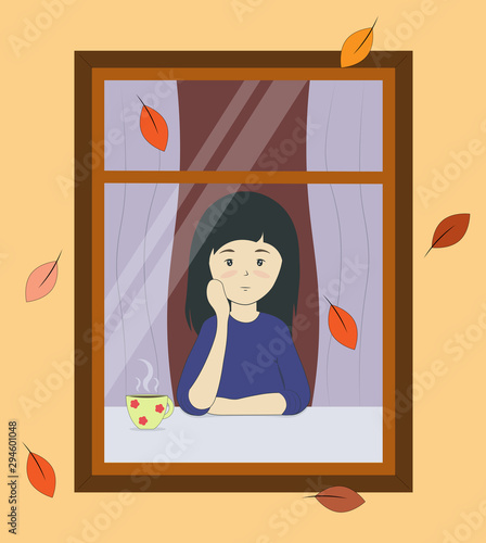 girl looks out the window in autumn