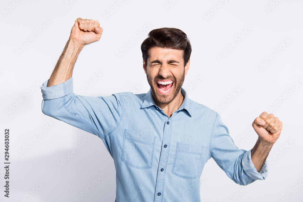 Photo of multiethnic guy celebrating lottery winning raising arms up yelling loudly rejoicing wear casual denim shirt isolated white color background Photo of multiethnic guy celebrating lottery winning raising arms up yelling loudly rejoicing wear casual denim shirt isolated white color background
