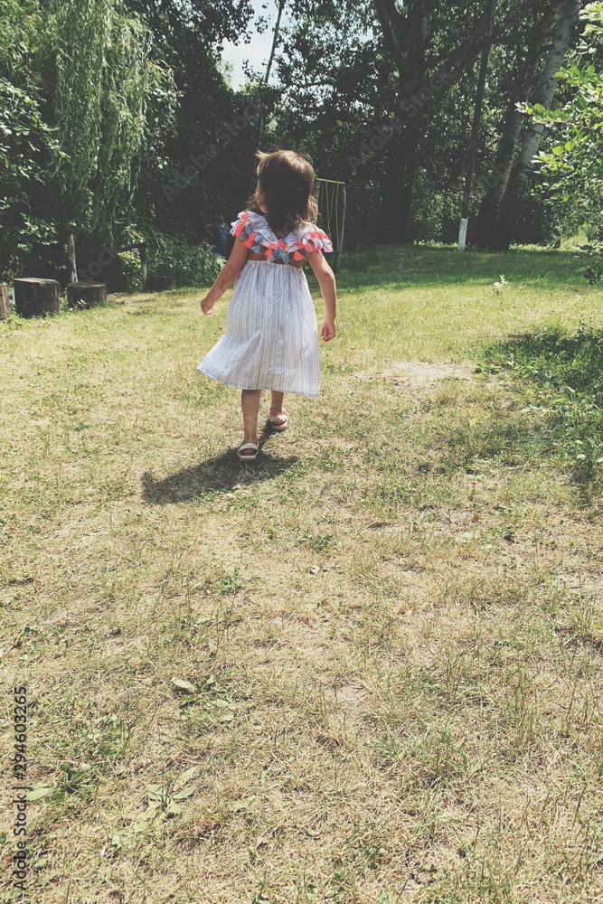 Little girl running on green grass. Beautiful warm summer evening. Little girl running on green grass. Beautiful warm summer evening.