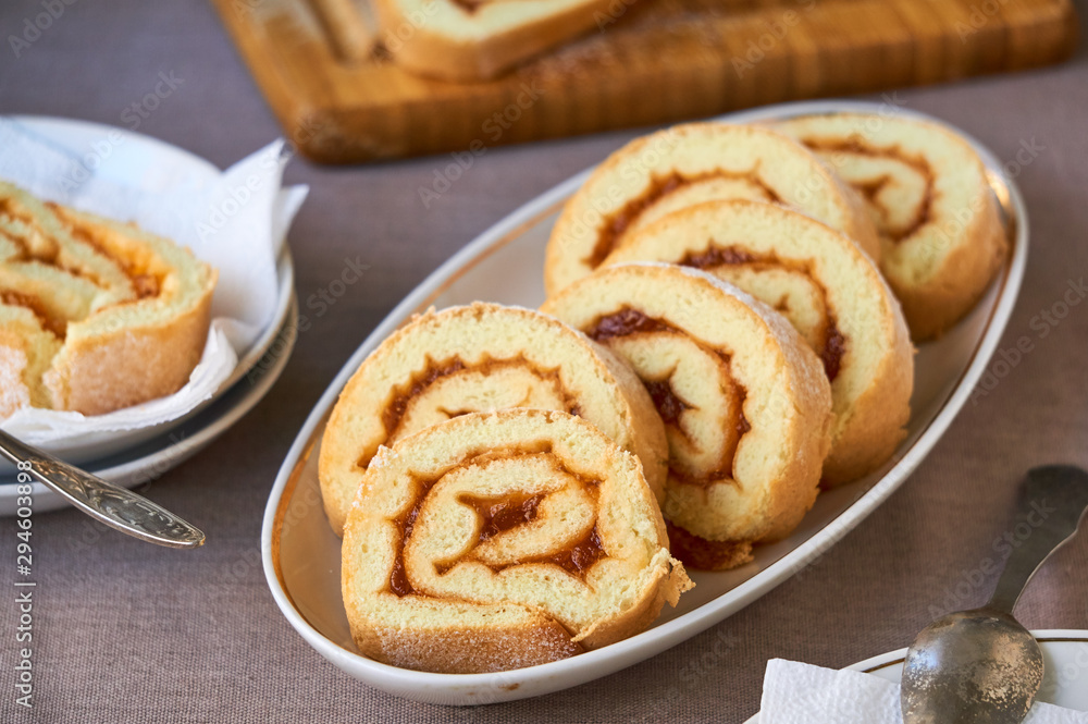 Slices of biscuit roll with apricot jam on a white plate Slices of biscuit roll with apricot jam on a white plate