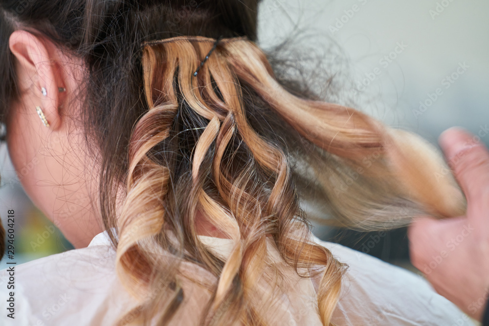 Naklejka premium Woman hairdresser making hairstyle in beauty salon