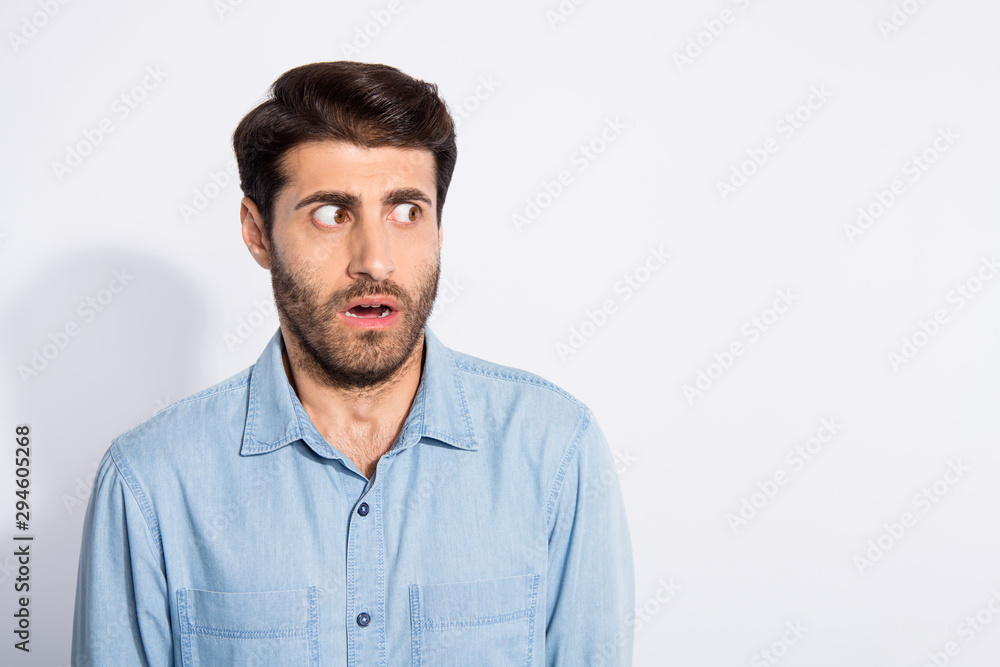 Close up photo of amazing multiethnic guy looking side empty space not believe eyes scary situation wear casual denim shirt isolated white color background Close up photo of amazing multiethnic guy looking side empty space not believe eyes scary situation wear casual denim shirt isolated white color background