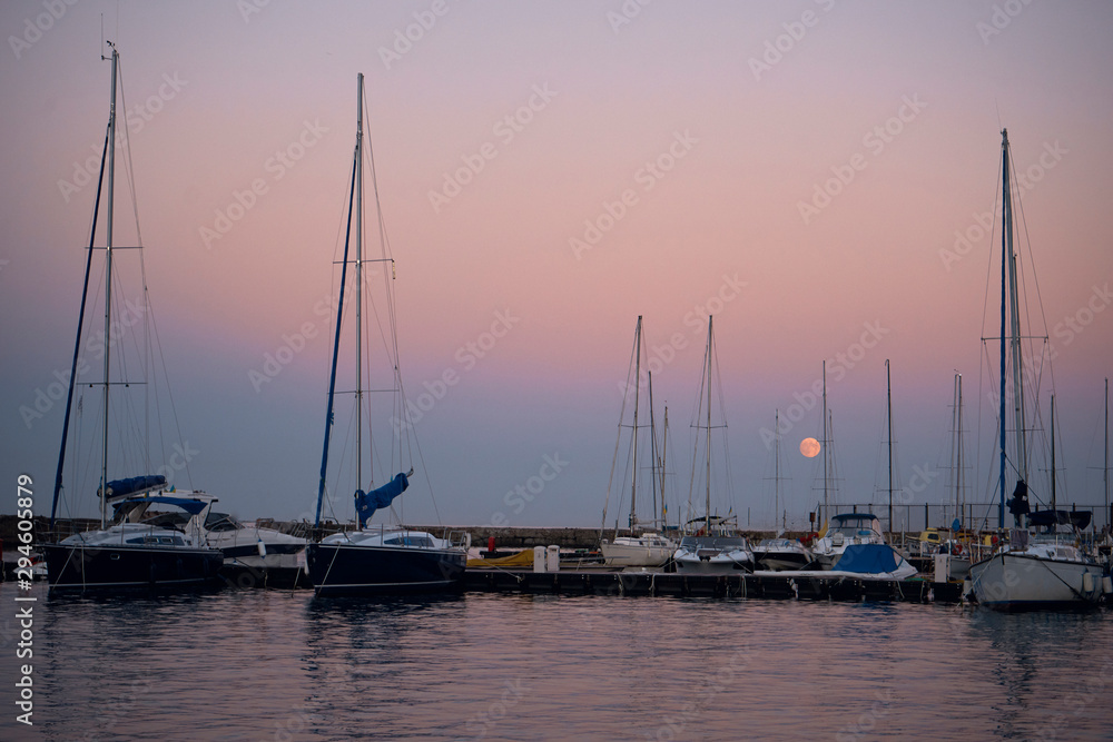 many beautiful yachts stand in the bay at sunset in the summer season