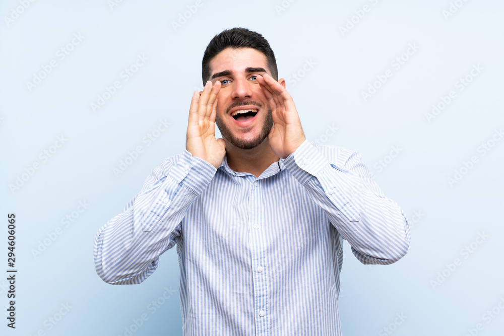 Caucasian handsome man over isolated blue background shouting with mouth wide open Caucasian handsome man over isolated blue background shouting with mouth wide open