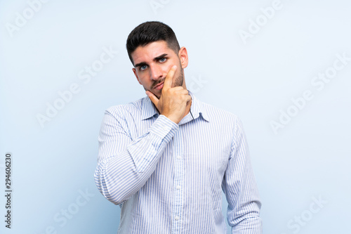 Caucasian handsome man over isolated blue background thinking an idea