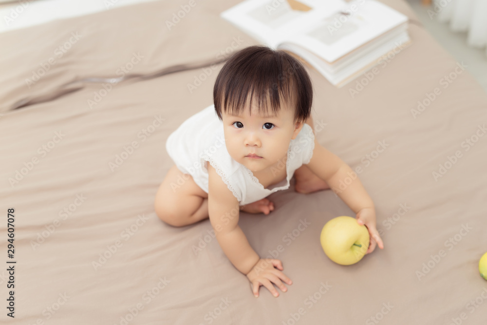 Portrait of baby girl playing with toy on bed at home Portrait of baby girl playing with toy on bed at home