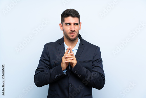 Handsome man over isolated blue background scheming something