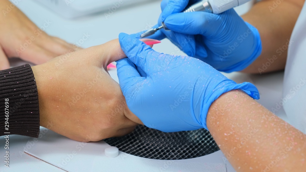 Hardware manicure. manicurist makes hardware manicure for woman in beauty salon. master of manicure removes cuticles on nails. Slow motion. hardware manicure Hardware manicure. manicurist makes hardware manicure for woman in beauty salon. master of manicure removes cuticles on nails. Slow motion. hardware manicure
