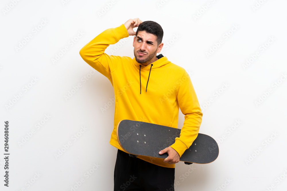 Handsome young skater man over isolated white wall having doubts and with confuse face expression