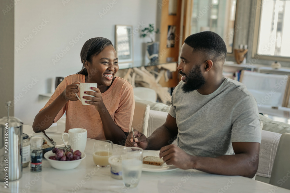 Young African American couple laughing together over breakfast Young African American couple laughing together over breakfast