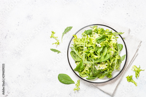 Green salad leaves mix on white top view.