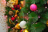 Christmas tree decorated with garlands and layers. Shiny and mirror toys close up. Multicolored decorations on Christmas trees.