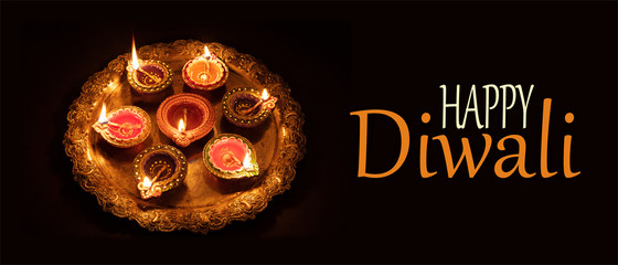 Diwali, Hindu festival of lights celebration. Diya oil lamps against dark background,