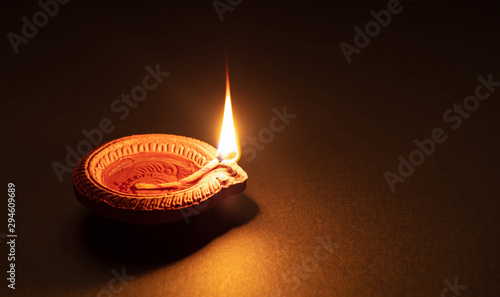 Diwali, Hindu festival of lights celebration. Diya oil lamp against dark background, photo