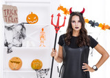 Evil woman with trident posing for halloween