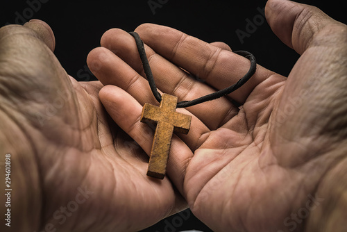 The crucifix is in the hands of a man who is praying for the blessing of his god with faith. photo