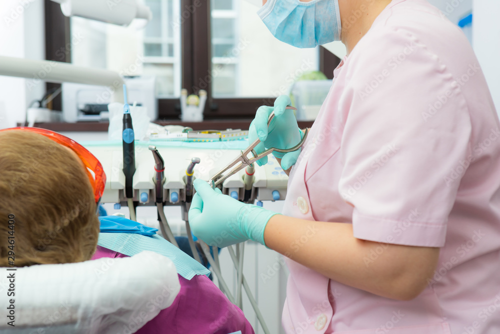 The dentist prepares a latex scarf with metal clips for the treatment of canals and pulpitis. The dentist prepares a latex scarf with metal clips for the treatment of canals and pulpitis.