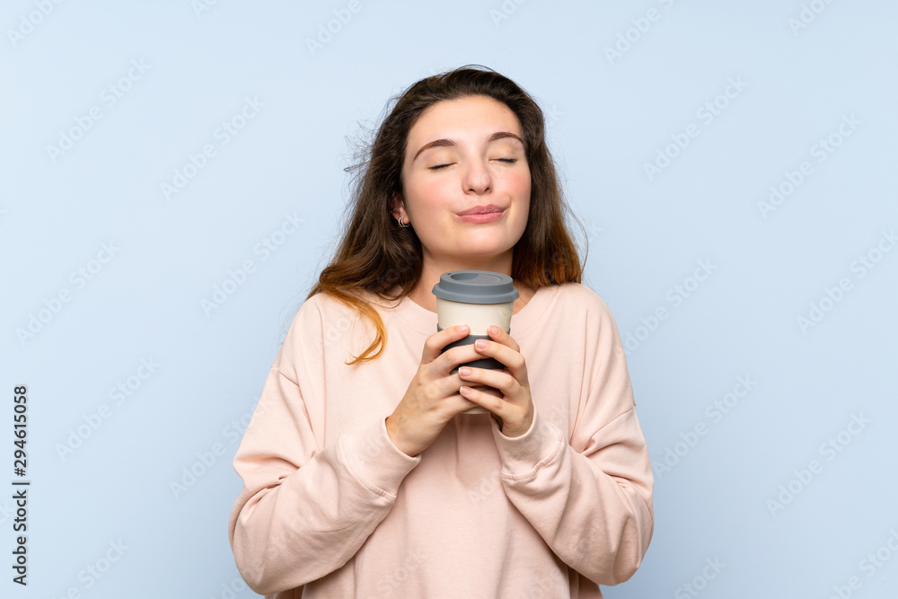 Young brunette girl over isolated blue background holding coffee to take away Young brunette girl over isolated blue background holding coffee to take away