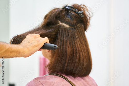 Woman hairdresser making hairstyle in beauty salon