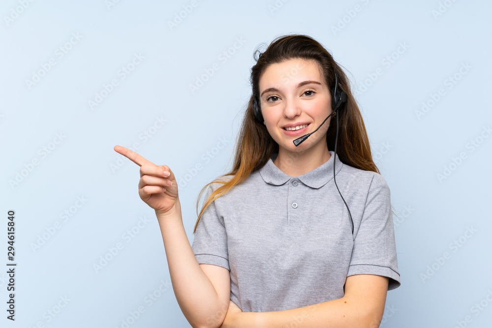 Young brunette girl over isolated blue background pointing side Young brunette girl over isolated blue background pointing side