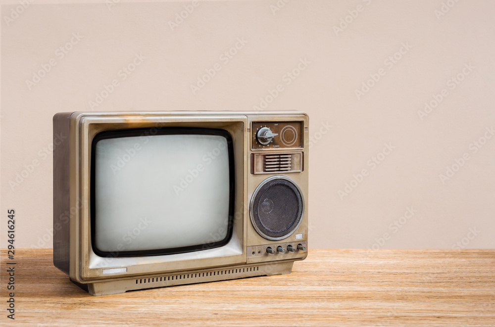 Retro old television receiver on wood table with cement wall background. Retro, vintage old TV