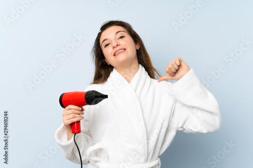 Young woman in a bathrobe with hair hairdryer proud and self-satisfied