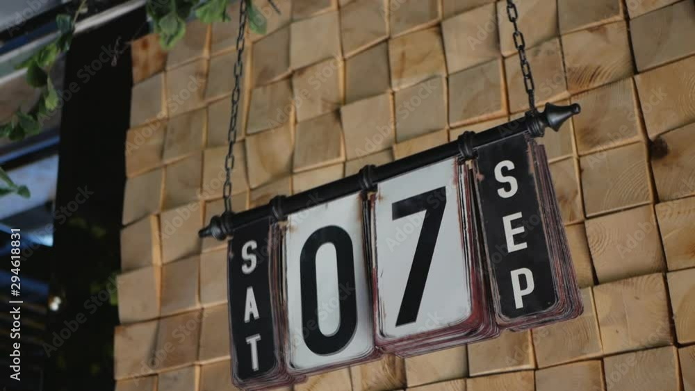 Hand flips the date on a hanging retro calendar Hand flips the date on a hanging retro calendar