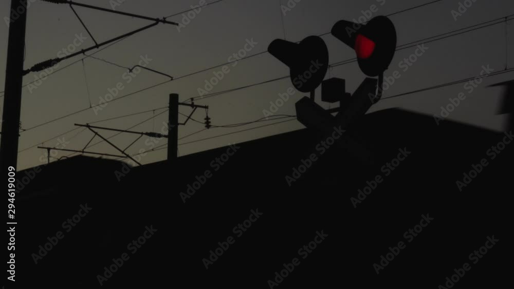 Container freight train passes through railway level crossing with blinking railroad signal red light. Export and import of goods by logistic company. Train crash and catastrophe or accident.