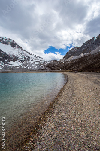 turquoise lake and snow mountain at yading china with the blue sky