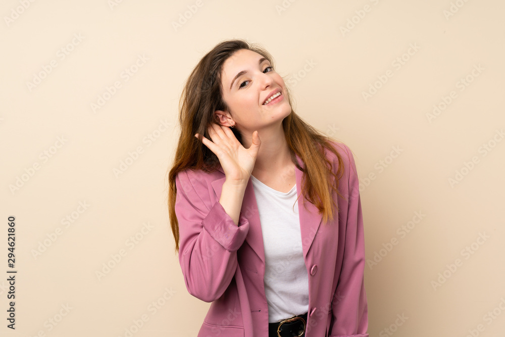 Young brunette girl with blazer over isolated background listening to something by putting hand on the ear Young brunette girl with blazer over isolated background listening to something by putting hand on the ear
