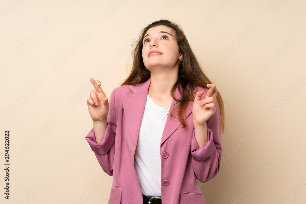 Young brunette girl with blazer over isolated background with fingers crossing and wishing the best Young brunette girl with blazer over isolated background with fingers crossing and wishing the best