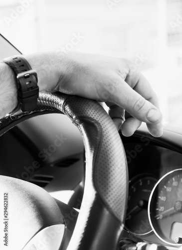 Selective focus male hand on the steering wheel, car driving and dashboard. Travel background