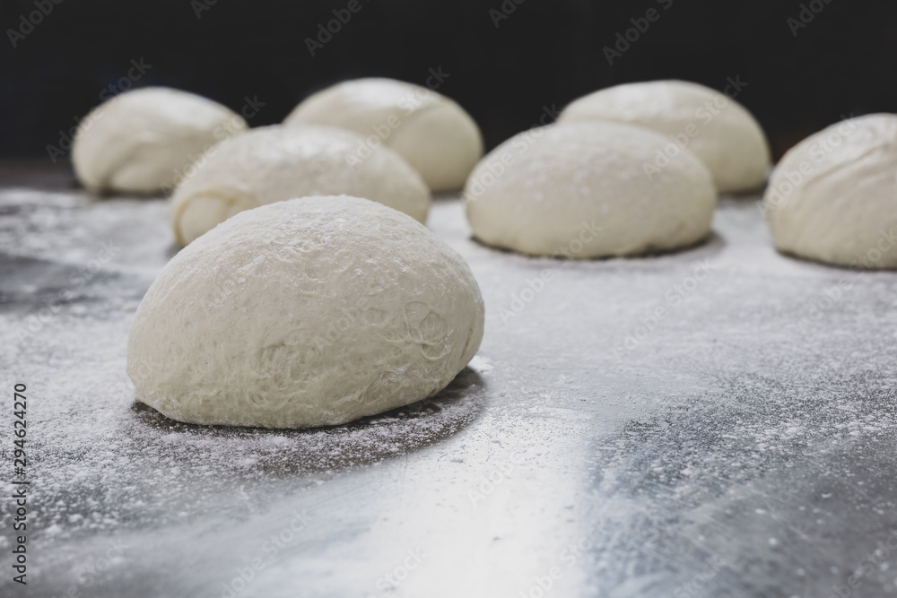 Ball of pizza dough on table with dusting of flour. Ball of pizza dough on table with dusting of flour.