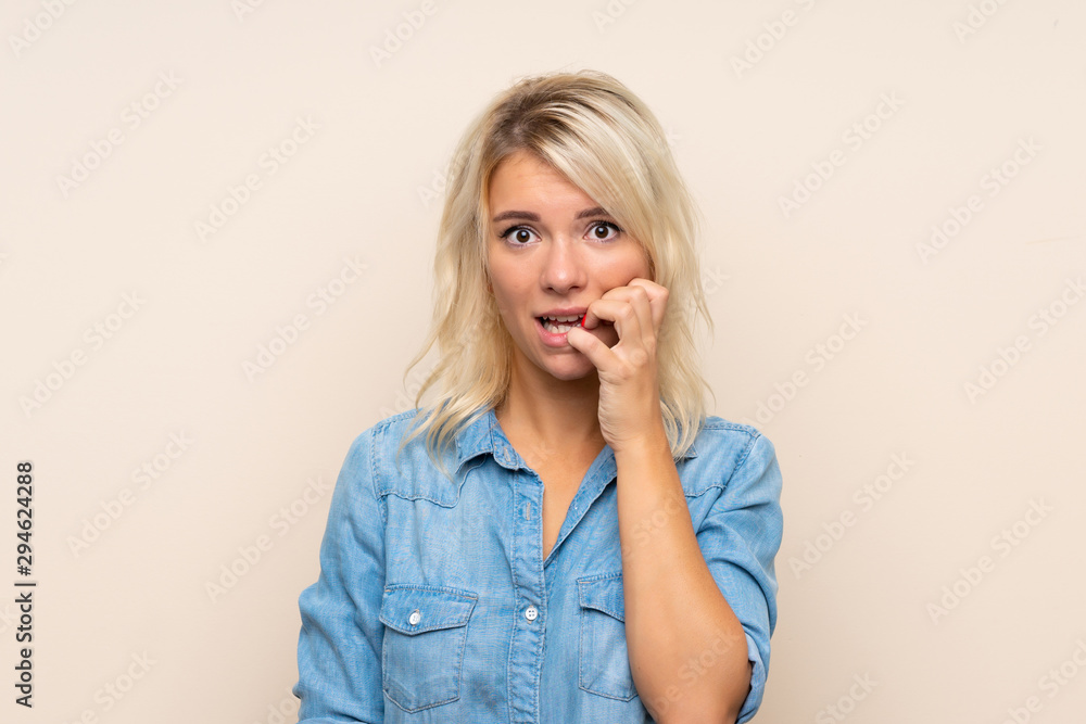 Young blonde woman over isolated background nervous and scared Young blonde woman over isolated background nervous and scared