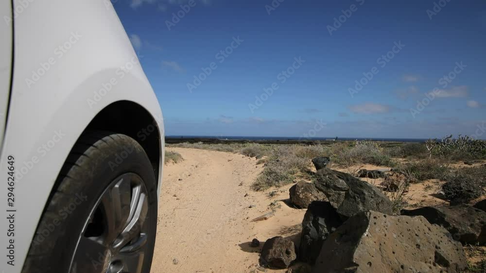 Drive by car to the Canary Islands. Shot of a car wheel and surrounding terrain with sand. Driving around Lanzarote. Professional shot of car wheel. Drive by car to the Canary Islands. Shot of a car wheel and surrounding terrain with sand. Driving around Lanzarote. Professional shot of car wheel.