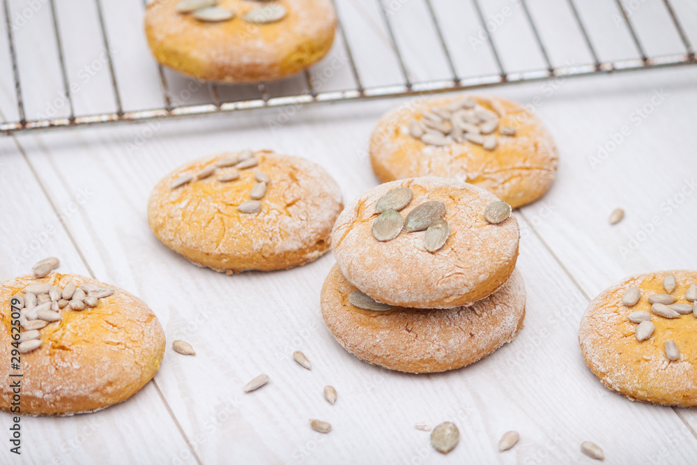 Tasty pumpkin cookies or biscuits with seeds on white wooden background. Tasty pumpkin cookies or biscuits with seeds on white wooden background.