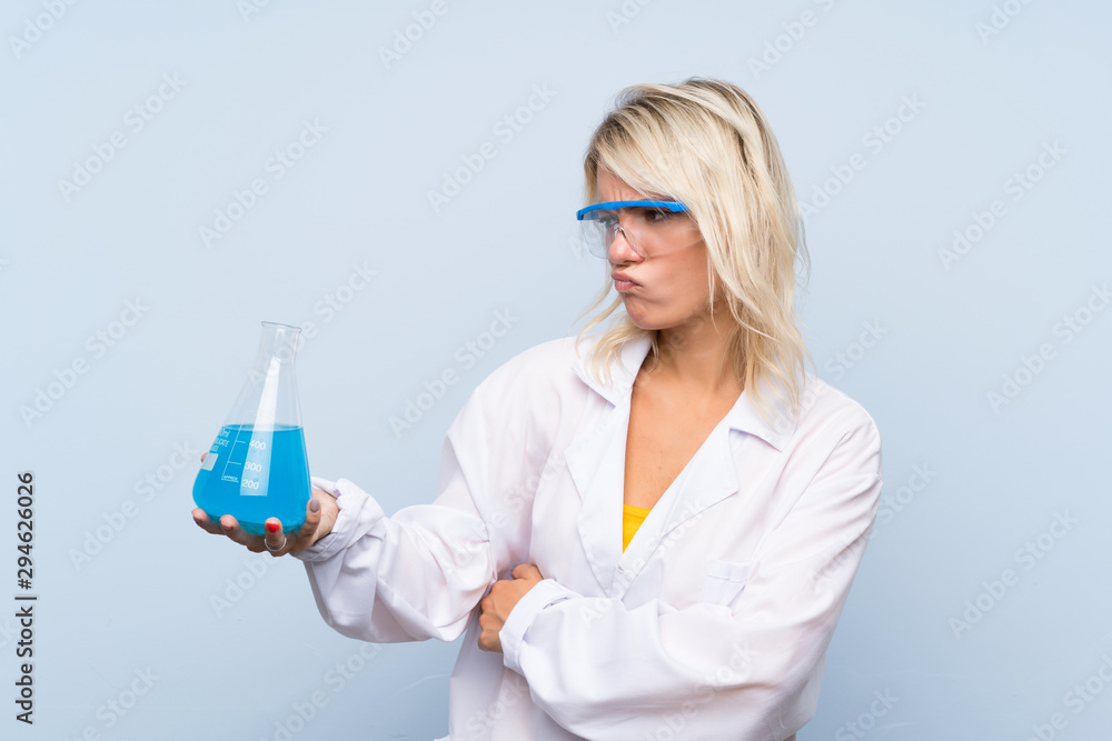 Young blonde woman over isolated background with a scientific test tube Young blonde woman over isolated background with a scientific test tube