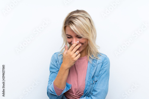 Young blonde woman over isolated white background smiling a lot